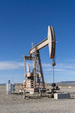 Çalışan bir yağ pompası mavi gökyüzüne çarpıyor. Colorado, ABD - 17 Mayıs 2023.