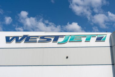 Close up of WestJet sign on the building at its World Headquarters in Calgary, Alberta, Canada - July 3, 2023. WestJet Airlines Ltd. is a Canadian airline. clipart