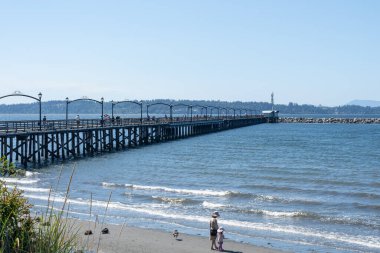 White Rock, British Columbia, Kanada 'daki White Rock Rıhtımı' nı ziyaret eden insanlar. White Rock Rıhtımı Kanada 'nın en uzun rıhtımıdır.. 