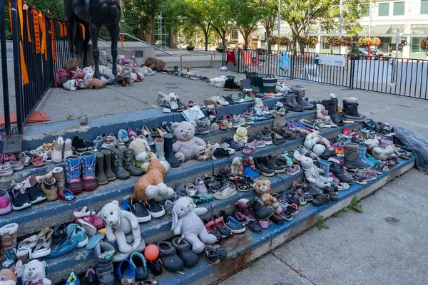 stock image Stuffed animals and shoes make up a memorial to residential school victims in front of Calgary City Hall. Calgary, Alberta, on July 3, 2023.