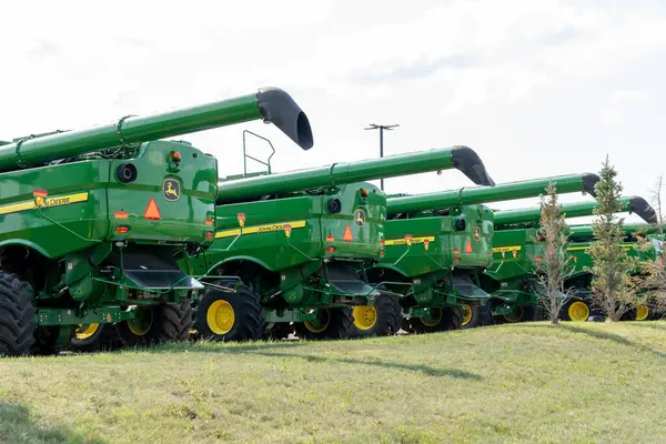 stock image Many new John Deere agriculture and farming equipment displayed at a Brandt facility in Calgary, Canada, July 3, 2023. John Deere is an American corporation that manufactures agricultural machinery.