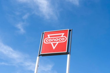 Wyoming, USA - May 8, 2023: A Conoco pole sign with blue sky in background at a gas station in Wyoming, USA. Conoco is an American petroleum brand. clipart