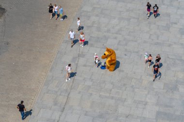 Varşova, Polonya - 27 Temmuz 2024: Meydanda turistlerle birlikte kahverengi ayı kostümlü bir sanatçının en iyi görüntüsü. Varşova, Polonya.