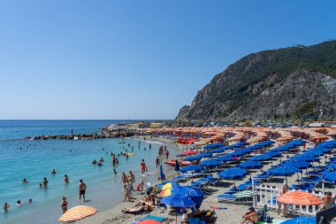 Cinque Terre, Liguria, İtalya - 22 Temmuz 2024: İtalya 'nın engebeli Riviera kıyı şeridi üzerindeki bir dizi sahil köyü olan Cinque Terre, İtalya' nın beş balıkçı köyünden biri olan Vernazza sahilindeki şemsiyeler.