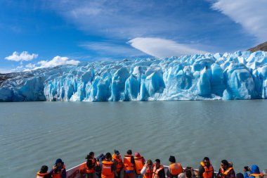 Puerto Natales, Şili - 2 Şubat 2023: Torres del Paine Ulusal Parkı, Puerto Natales, Şili 'deki Gri Buzul' dan ayrılan bir buzdağını izleyen turistler 