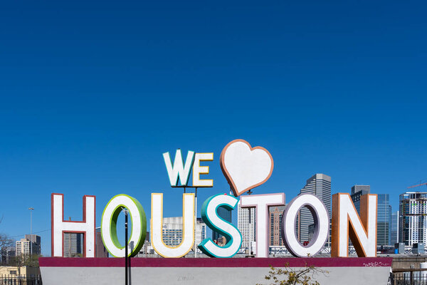Houston, Texas, USA - March 13, 2022: The sign We Love Houston with Downtown Houston in background is shown in Houston, Texas, USA. Text space.