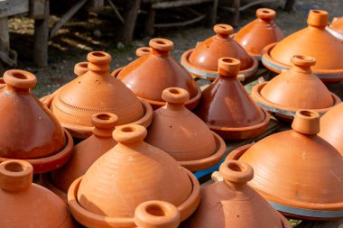 Rafta satılık Tagine kil kapları sergileniyor. Fas 'ta. Tagine koni şeklinde bir tencere. Düz kenarlı ve uzun konik kapağı var..