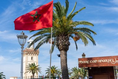 Tangier, Morocco - October 20, 2024: A flag of Morocco is seen at Cap Spartel Lighthouse near Tanger city, Morocco. Cape Spartel is the oldest lighthouse in Morocco. clipart