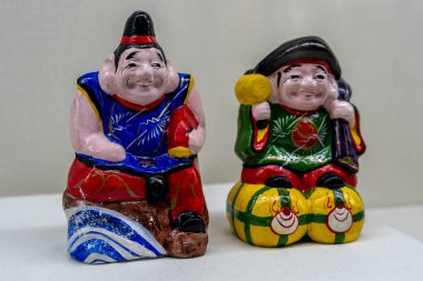 İki parlak boyalı seramik oyuncak bebek. 