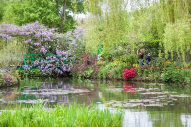 Giverny, Fransa - 9 Mayıs - Claude Monet 'nin evi ve bahçesinde mor çiçekli köprü, Giverny' deki ünlü empresyonist ressam Claude Monet 'in evi Paris' ten 80 km uzaklıkta (50 mi).