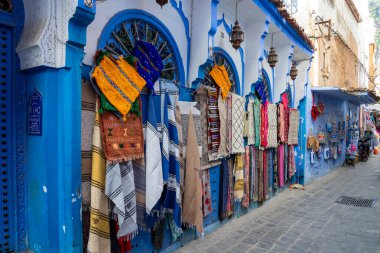 Chefchaouen, Fas - 23 Ekim 2024: Fas 'ın başkenti Chefchaouen' de turist hatıraları sergilenen mavi renkli evler ve sokaklar. Chefchaouen genellikle mavi şehir olarak adlandırılır.