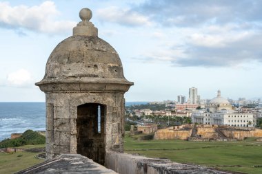 San Juan, Porto Riko 'da günbatımında şehrin arka planında bulunan Castillo San Cristobal Kalesi' nde taret. 1783 'te İspanya tarafından San Juan şehrine yapılan kara saldırılarına karşı korunmak için inşa edildi.
