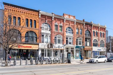 Toronto, Canada - May 5, 2019: Stores on the Queen West close to Spadina av. in Toronto Canada. Queen West has become an international arts centre and a tourist attraction in Toronto. clipart