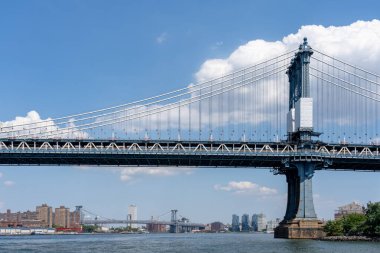 New York City, ABD - 19 Ağustos 2022: Manhattan Köprüsü New York City, New York, ABD 'de arkaplanlı binalar. Manhattan Köprüsü, Doğu Nehri 'ni geçen bir asma köprüdür..