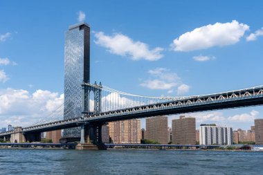 New York City, ABD - 19 Ağustos 2022: Manhattan Köprüsü New York City, New York, ABD 'de arkaplanlı binalar. Manhattan Köprüsü, Doğu Nehri 'ni geçen bir asma köprüdür..