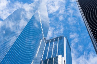Arka planda mavi gökyüzü olan modern yüksek katlı ofis binalarına bakıyorum. New York City, ABD