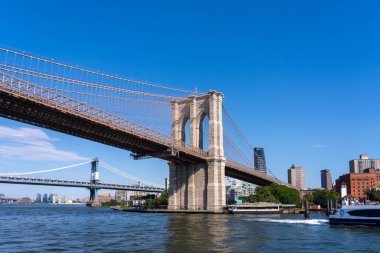New York City, ABD - 19 Ağustos 2022: Brooklyn Köprüsü, arka planda binalar. New York, New York, ABD. Brooklyn Köprüsü bir hibrit kablo süspansiyon köprüsü..