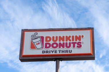 Mavi arkaplanlı Dunkin 'Donuts direği tabelası. Springfield, MA, USA, 12 Kasım 2023. Dunkin, çok uluslu bir kahve ve çörek şirketidir..