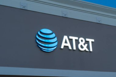 Pearland, TX, ABD - 12 Nisan 2024 AT ve T logosunu kapatın ve alacakaranlıkta binayı imzalayın. AT and T Inc., Amerikan çokuluslu telekomünikasyon şirketi..