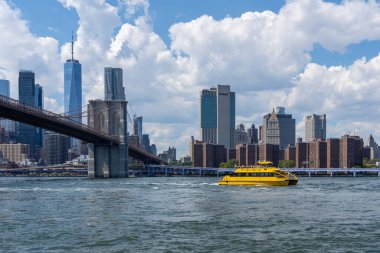 New York City, ABD - 19 Ağustos 2022: Brooklyn Köprüsü 'nün arka planında New York City, New York, ABD' deki binalar. Brooklyn Köprüsü bir hibrit kablo süspansiyon köprüsü..