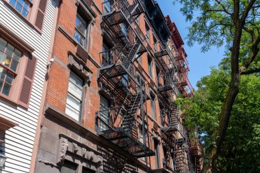 Yangın merdivenleri olan eski kırmızı tuğlalı bir apartman. New York City, ABD - 20 Ağustos 2022.