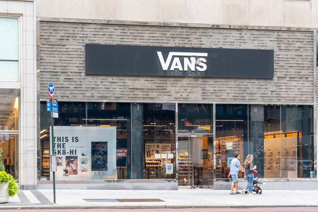 New York City, USA - August 17, 2022: People walking in front of a Vans store on Fifth Ave in New York City, USA. Vans is an American apparel, accessories, and skateboarding shoes brand.