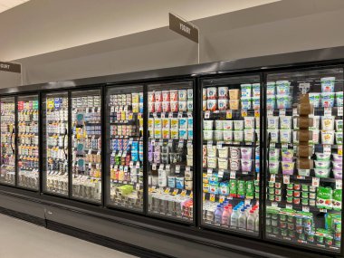 Boston, MA, ABD - 9 Kasım 2023: Bir süpermarketteki dondurucuların raflarında satılık yoğurt kutuları çeşitliliği. Boston, MA, ABD.