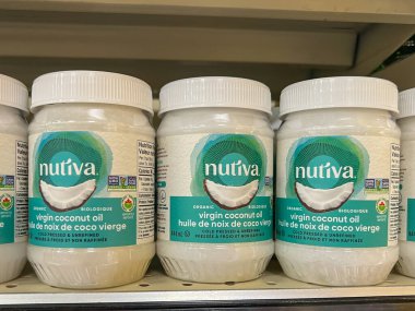 Alberta, Kanada - 3 Temmuz 2023: Nutiva Organik Hindistan cevizi yağı 444ml şişeleri bir süpermarkette raflarda satılıyor. Alberta, Kanada.