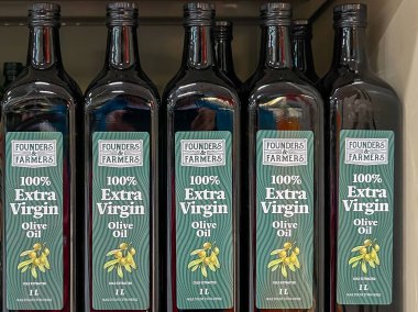 Alberta, Kanada - 3 Temmuz 2023: Kurucular süpermarkette raflarda% 100 Ekstra Virgin Zeytinyağı 1L şişeleri buldular. Alberta, Kanada.