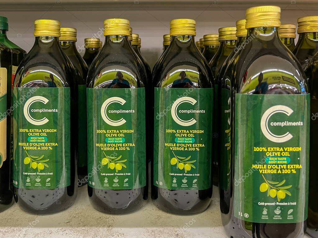 Calgary, Alberta, Canada, - July 18, 2023: Compliments Olive Oil Extras Virgin Rich Taste 1 L bottles for sale on the shelves in a supermarket. Calgary, Alberta, Canada.