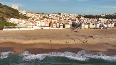 Portekiz 'deki Nazare Kasabası. Plaj ve şehir manzarası. İnsansız hava aracı bakış açısı. 4k