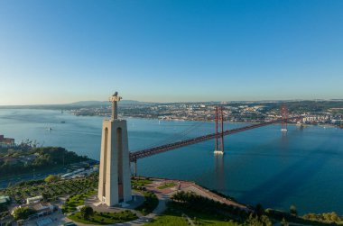 Kral İsa 'nın mabedi. Portekiz 'deki Lizbon şehrine tepeden bakan İsa' nın Kutsal Kalbi 'ne adanmış Katolik anıtı. 25 Nisan köprüsü (Ponte 25 de Abril) arka planda