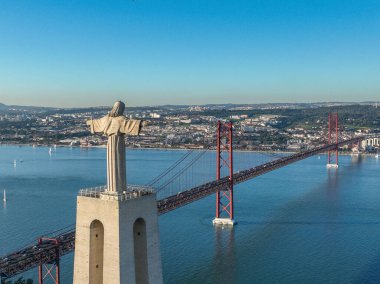 Kral İsa 'nın mabedi. Portekiz 'deki Lizbon şehrine tepeden bakan İsa' nın Kutsal Kalbi 'ne adanmış Katolik anıtı. 25 Nisan köprüsü (Ponte 25 de Abril) arka planda
