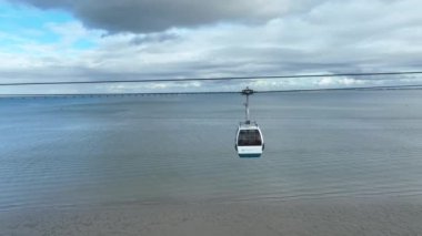 Milletler Parkı 'ndaki Telecabine Lisboa (Parque das Nacoes). Lizbon 'un modern bölgesinde bir yaz günü Tagus nehrinin üzerinde kablolu bir araba. 4k