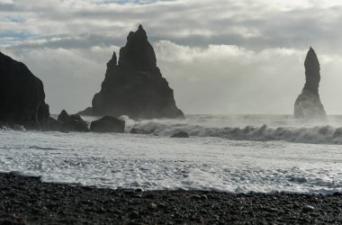 İzlanda 'daki Black Sand Beach Reynisfjara' ya yakın. Sudaki Kayalar. Okyanus Dalgaları. Rüzgarlı Sabah.