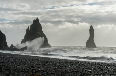 İzlanda 'daki Kara Kum Sahili Reynisfjara. Sudaki Kayalar ve Okyanus Dalgaları