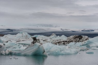 Jokulsarlon Buzul Gölü ve Arka plandaki Dağ. Clooudy Sky ve Buzdağları.