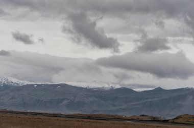 Arkaplanda Bulutlu Gökyüzü ve Dağlı İzlanda manzarası