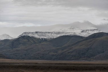 Arkaplanda Bulutlu Gökyüzü ve Dağlı İzlanda manzarası