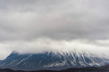 Karlı Dağların Üzerinde Bulutlu İzlanda manzarası
