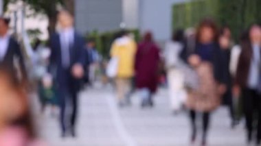 Blurry People Walking on the Sidewalk. Business District. Rush Hour Time. Asian City and Asian People. Blurry Background.