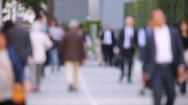 Blurry People Walking on the Sidewalk. Business District. Rush Hour Time. Asian City and Asian People. Blurry Background.