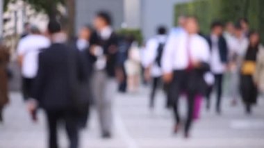 Blurry People Walking on the Sidewalk. Business District. Rush Hour Time. Asian City and Asian People. Blurry Background.