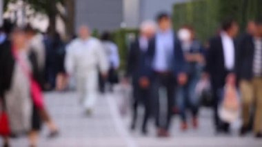 Blurry People Walking on the Sidewalk. Business District. Rush Hour Time. Asian City and Asian People. Blurry Background.