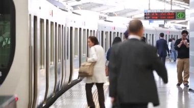 Metro Train Station Platform in Tokyo. People are Rushing on Platform in Underground Metro Train Station During Rush Hour. Train is Ready To Depart.