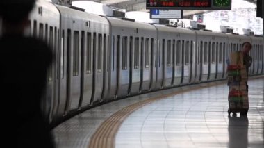 Metro Train Station Platform in Tokyo. Underground Metro Train During Rush Hour is Ready to Depart. People are Running to the Train. Conductor Checking Time. Asian commuters traveling.