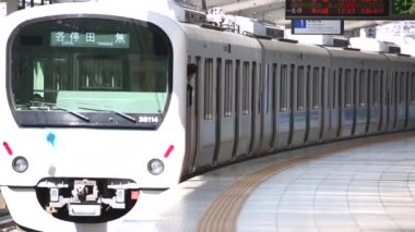 Metro Train Station Platform in Tokyo. Underground Metro Train During Rush Hour is Ready to Depart. Train is Leaving Station. Asian commuters traveling.
