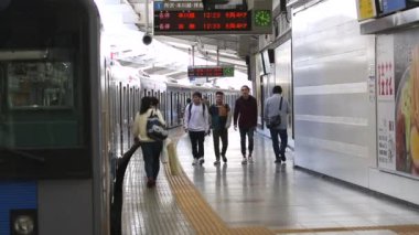 Metro Train Station Platform in Tokyo. Underground Metro Train During Rush Hour. People are Walking on Platform. Asian commuters traveling.