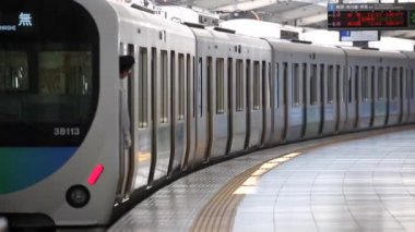 Metro Train Station Platform in Tokyo. Underground Metro Train Station During Rush Hour. The Train is Departing. Asian commuters traveling.