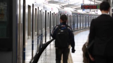 Metro Train Station Platform in Tokyo. Underground Metro Train During Rush Hour. People are Walking on Platform. Conductor Leaves the Train. Asian commuters traveling.